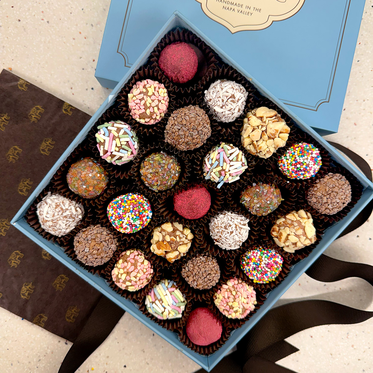 A box of assorted colorful chocolate truffles and candies.