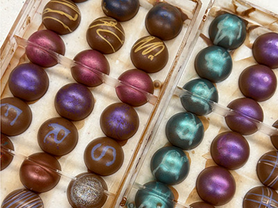Colorful assorted chocolates in plastic trays.